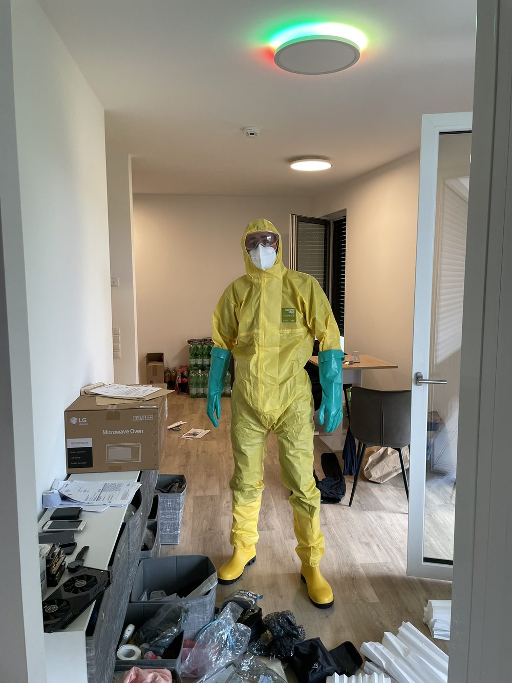 Mitarbeiter in Schutzkleidung in einer Wohnung